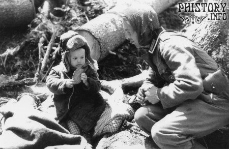 Немецкий солдат угостил хлебом русского мальчика.